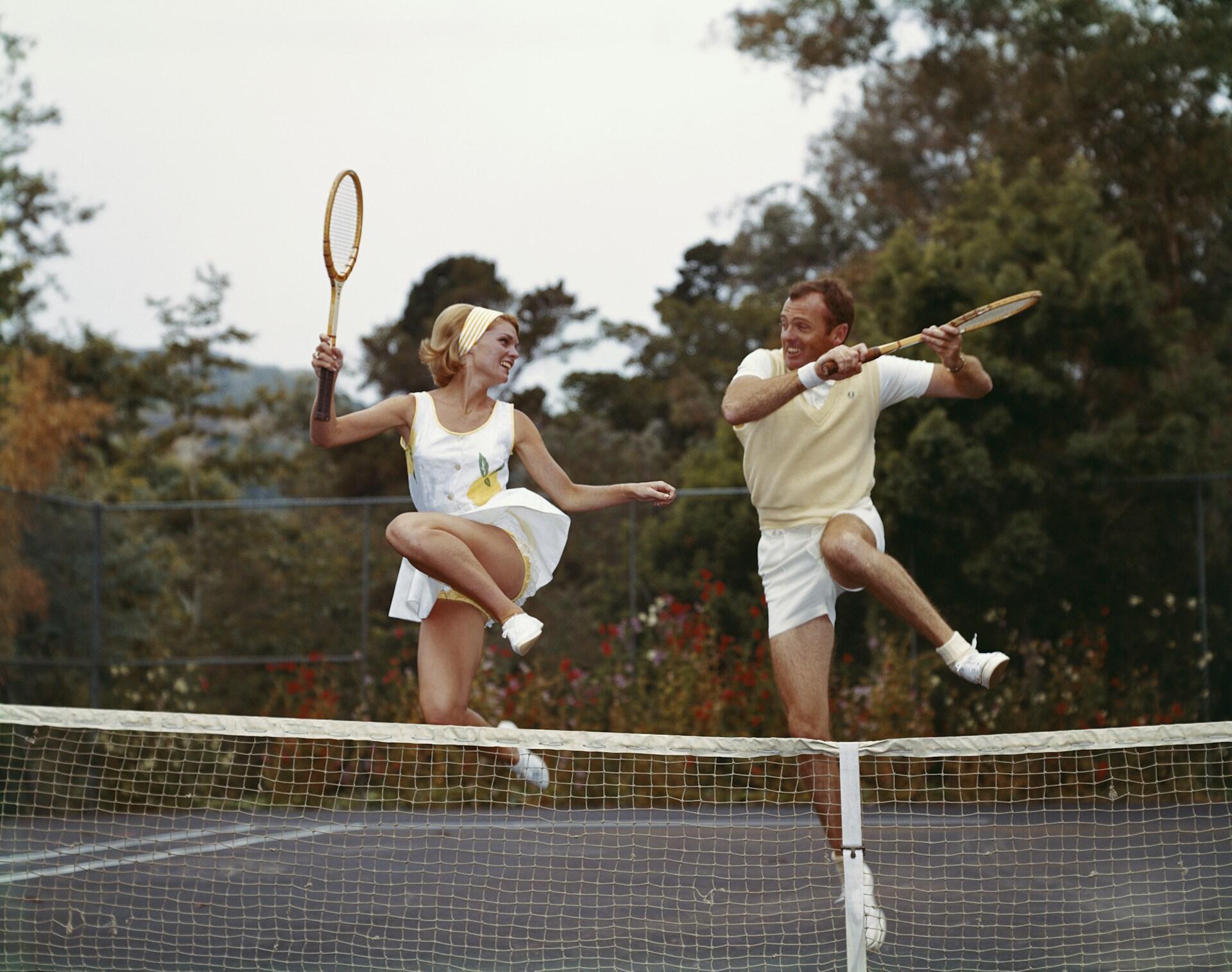 Un homme et une femme s'amusent à jouer au tennis.