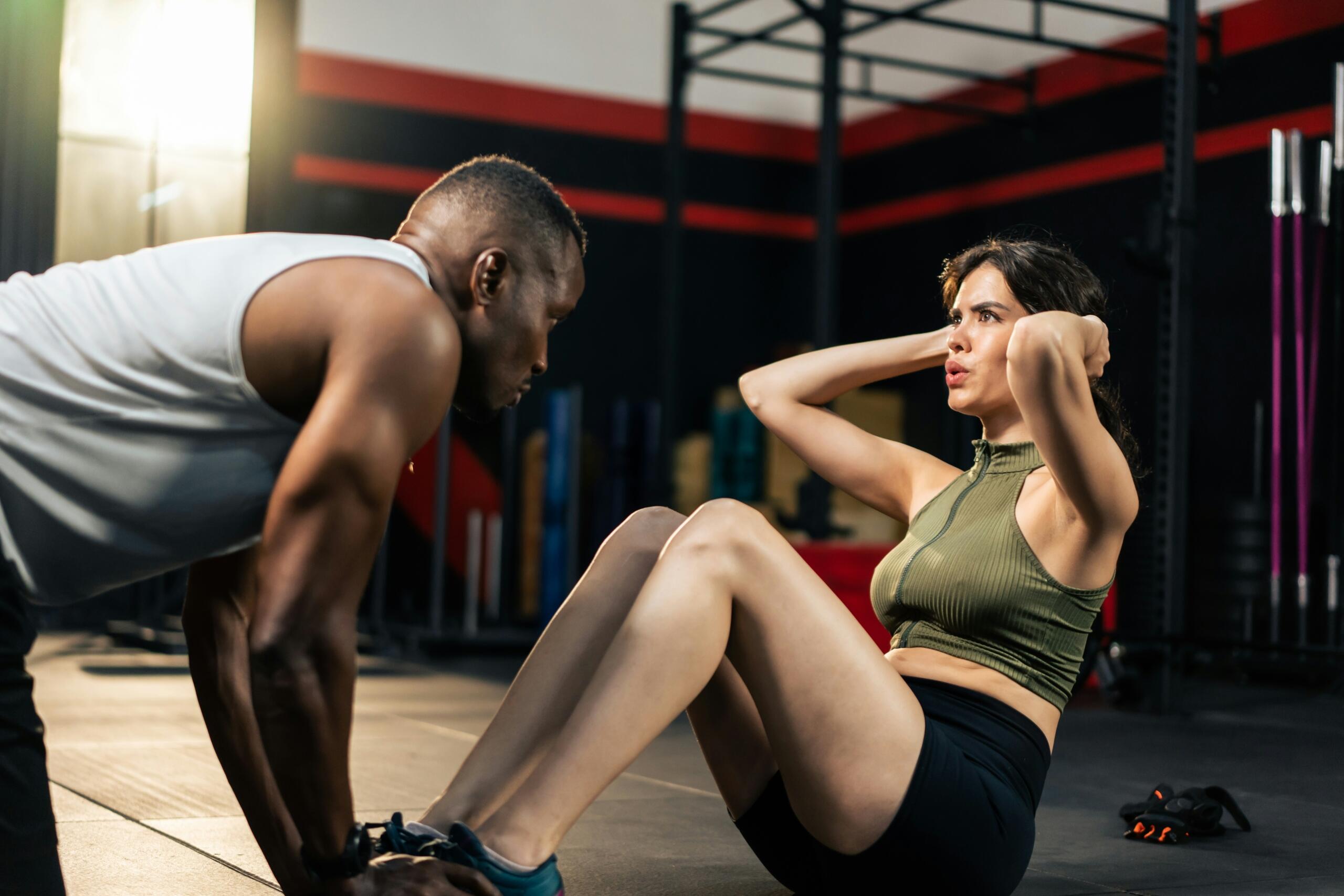 La fille fait des exercices dans la salle de sport avec un professeur.
