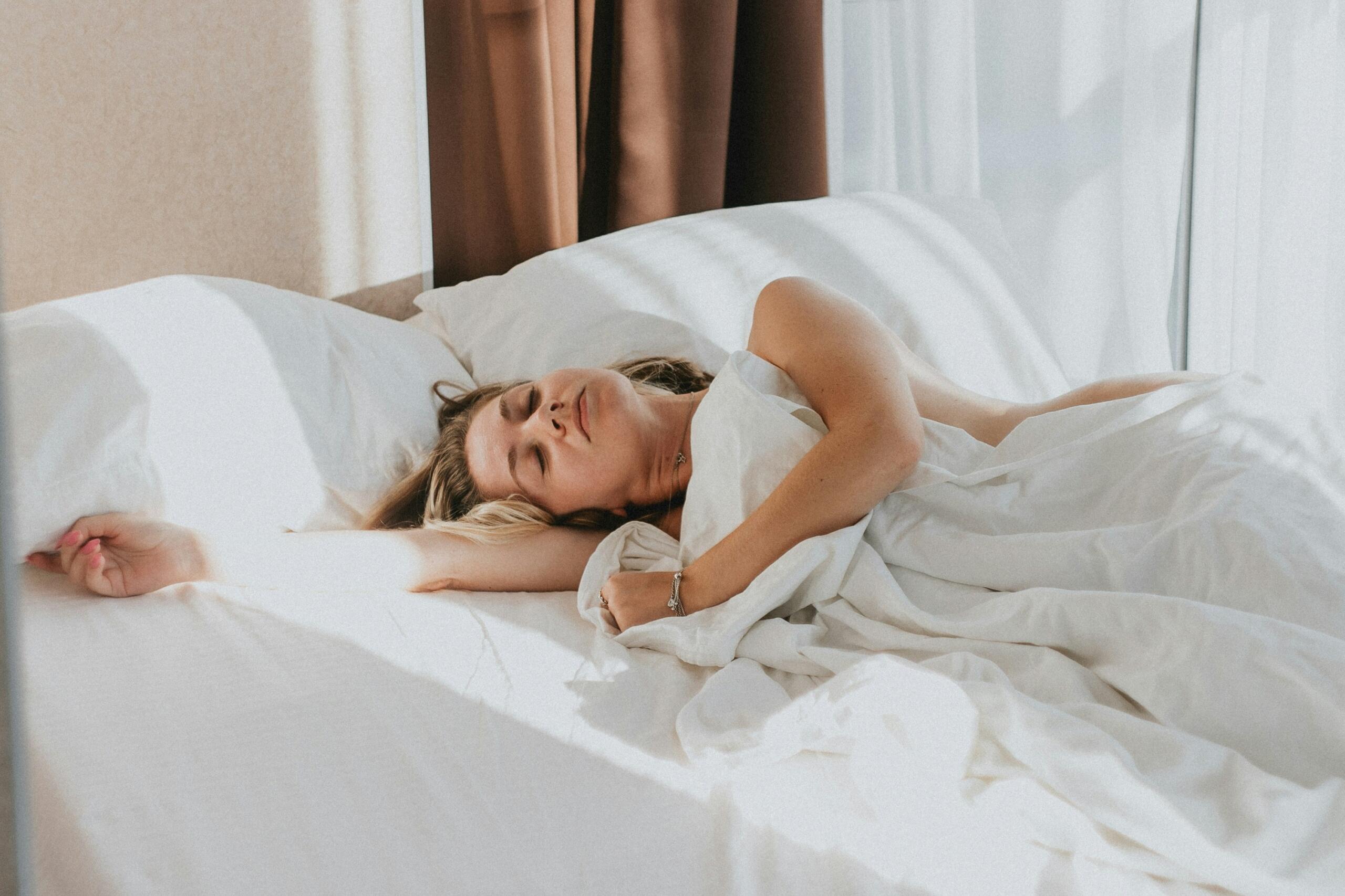 Une femme dort sur son lit.